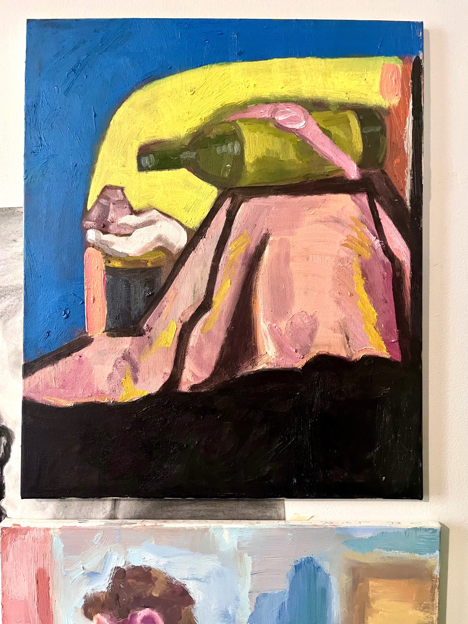 Bright still life painting of wine bottle atop a pink cloth