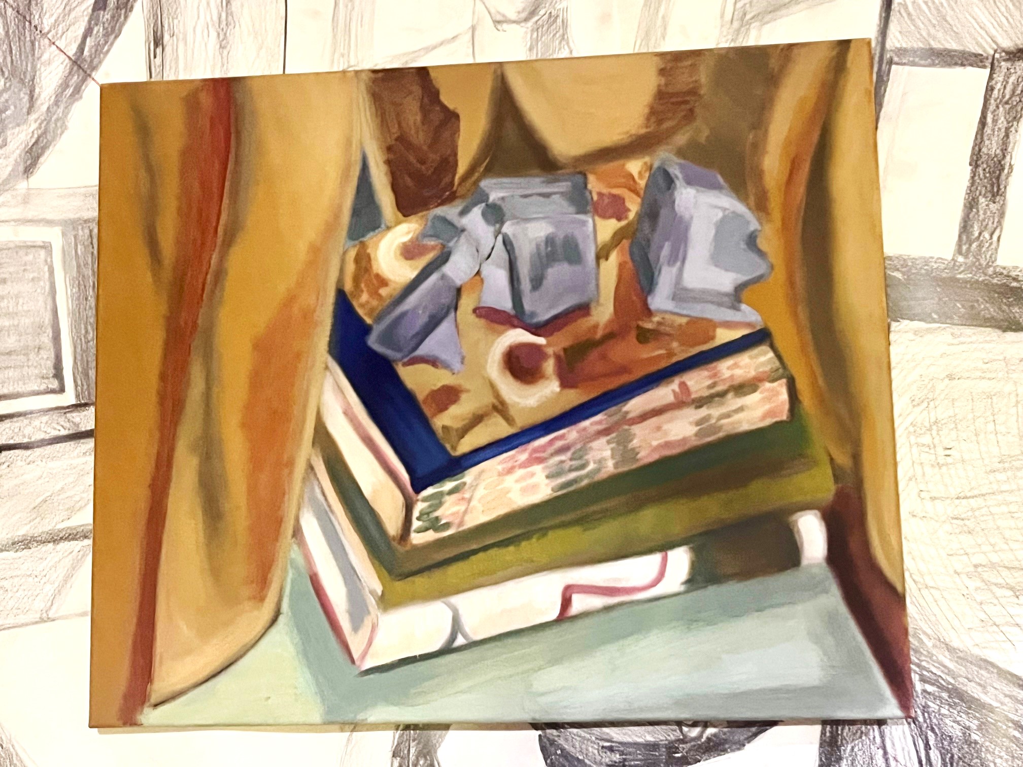 Mostly golden colored curtain Window painting of books stacked with a rock formation on top